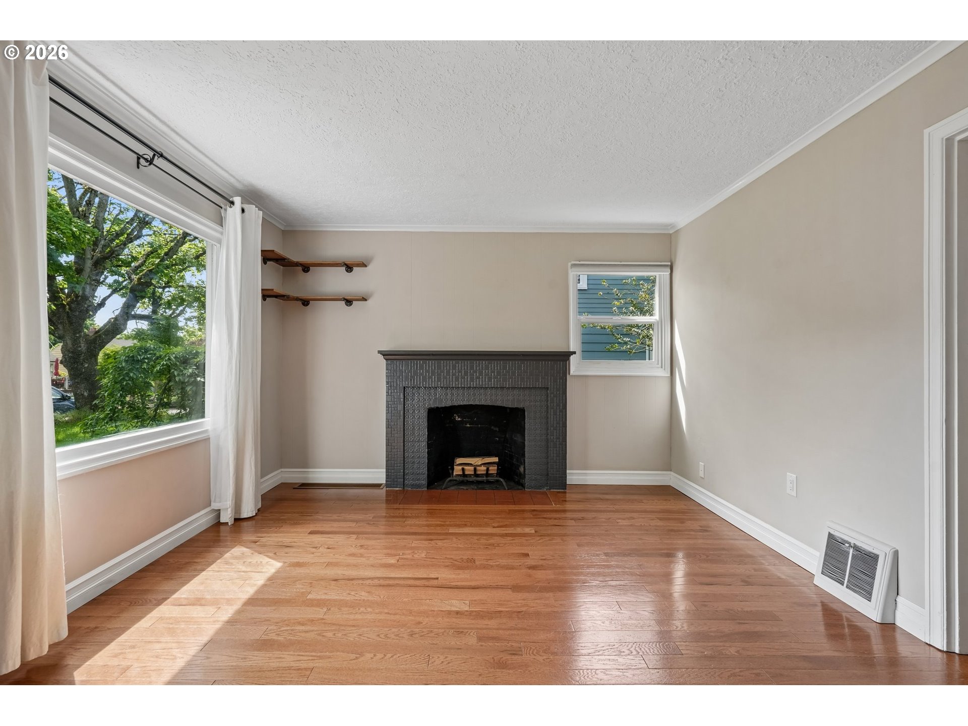4204 Fir Street Vancouver, WA 98660 - Photo 6 of 37 a view of empty room with wooden floor and a fireplace