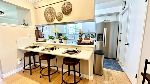 a kitchen with stainless steel appliances a table chairs and a refrigerator