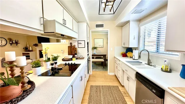 a large kitchen with lots of counter top space a sink a stove and a window