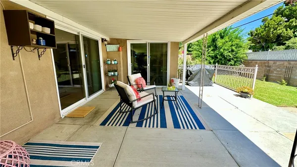 a view of a patio with table and chairs under an umbrella