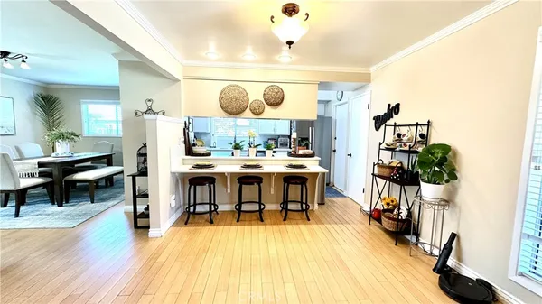 a dining room with stainless steel appliances kitchen island granite countertop a table chairs and a refrigerator