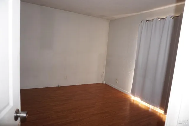 a view of a small space with wooden floor and a window