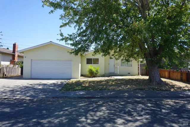 a front view of a house with a yard and trees