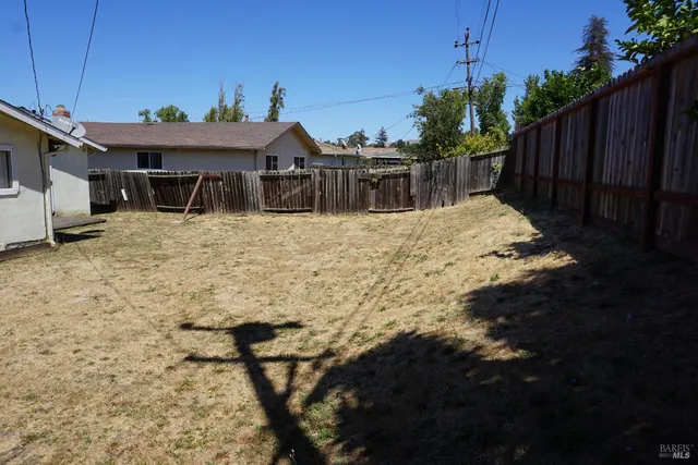 a view of empty room with wooden floor and fireplace