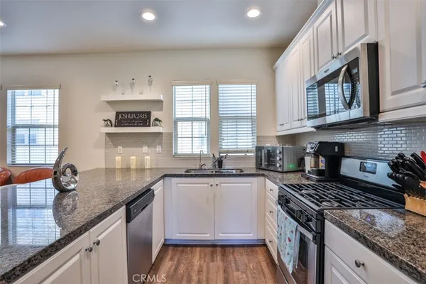 a kitchen with granite countertop a sink stove and cabinets