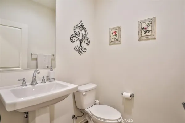 a bathroom with a sink mirror and a toilet