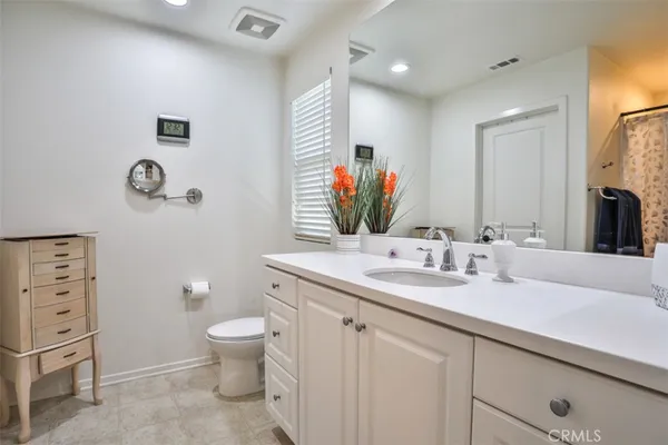 a spacious bathroom with a granite countertop toilet sink and mirror