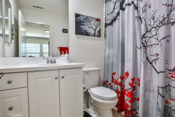 a bathroom with a sink vanity mirror and toilet