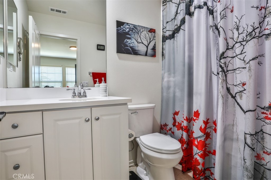 877 Orchid Way Azusa, CA 91702 - Photo 23 of 40 a bathroom with a sink vanity mirror and toilet