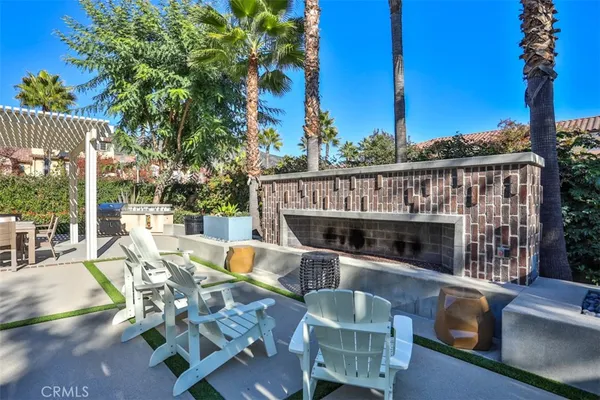 a view of a patio with couches table and chairs under an umbrella with wooden floor