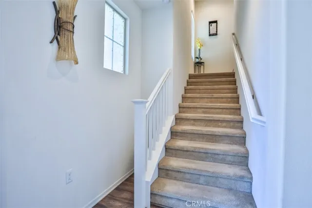 a view of staircase with wooden floor and white walls