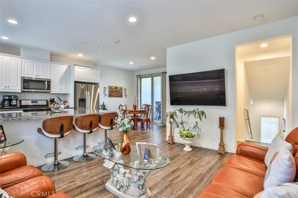 a living room with furniture kitchen view and a flat screen tv