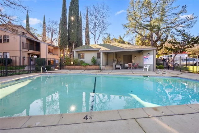 a view of a swimming pool with a bench and tables