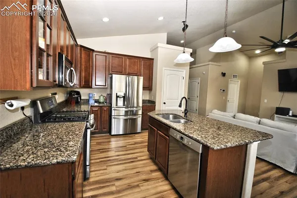 a kitchen with stainless steel appliances granite countertop a sink stove and refrigerator