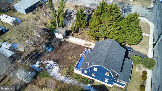 an aerial view of a house with a yard and a large tree