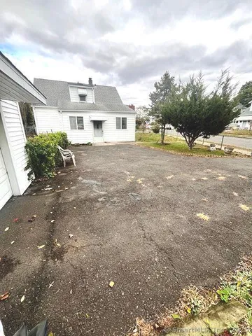 a front view of a house with a yard and potted plants