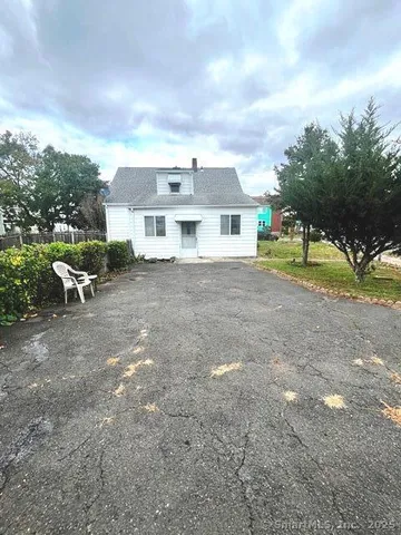 a view of a house with a yard and sitting area