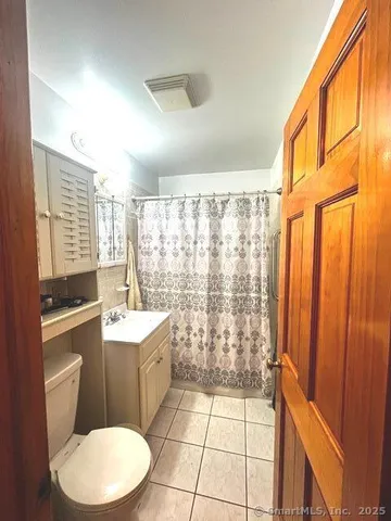 a bathroom with a sink a toilet a mirror and shower