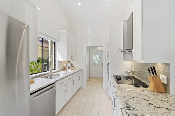 a large white kitchen with a refrigerator a stove a sink and a refrigerator