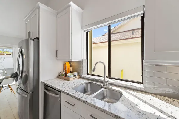 a close view of a sink and a refrigerator in a kitchen