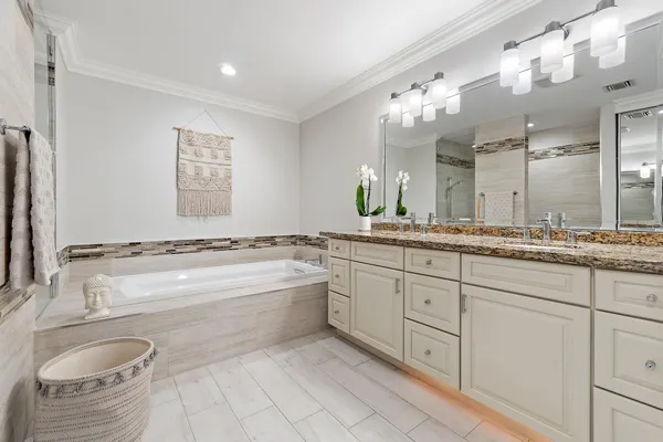 a bathroom with a granite countertop sink mirror and bathtub