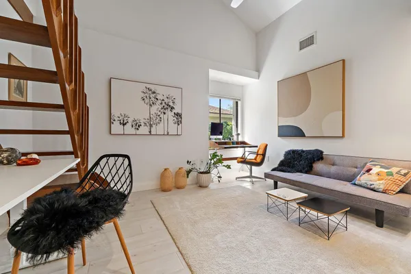 a living room with furniture and a painting on the wall