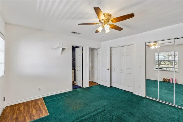 a view of a livingroom with a ceiling fan and wooden floor