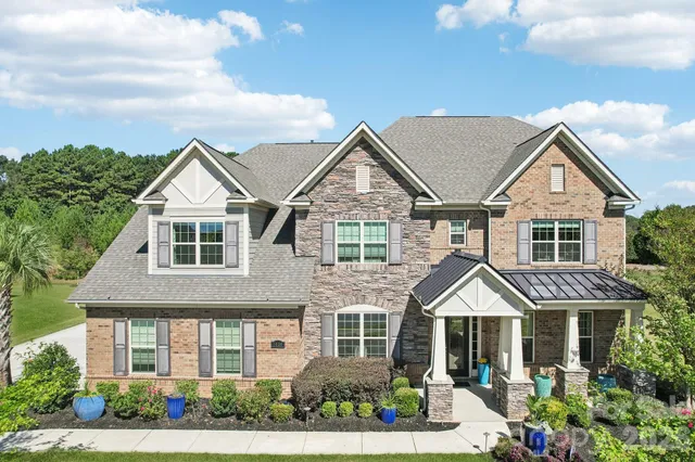 a view of a house with many windows and plants