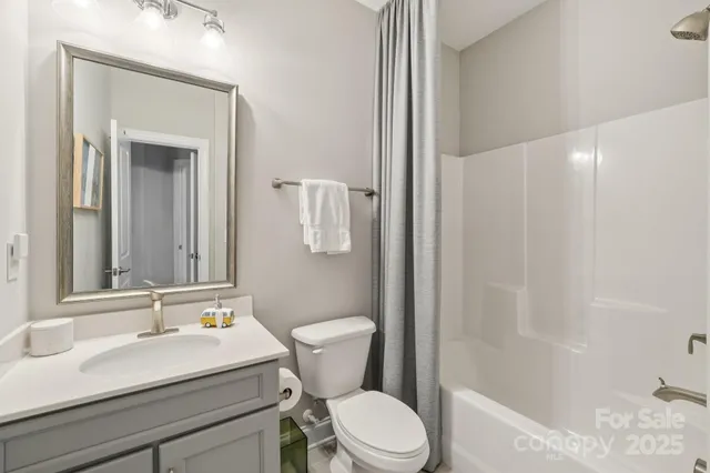 a bathroom with a sink a toilet a mirror and shower