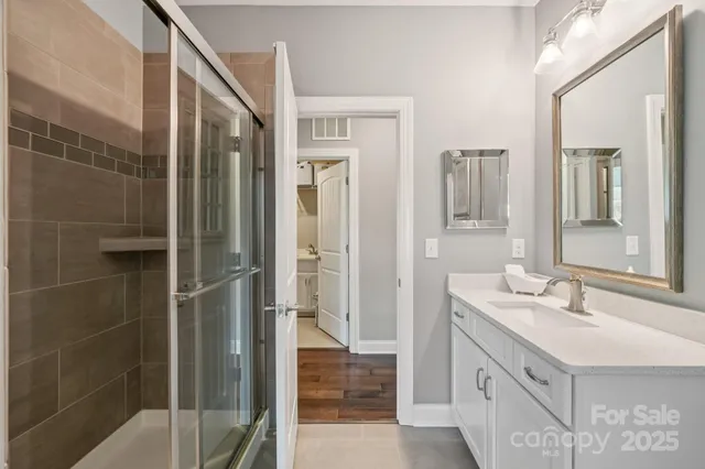 a bathroom with a double vanity sink a mirror and a shower