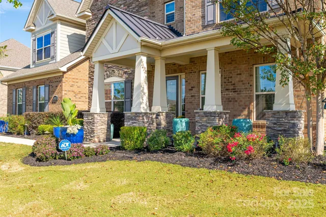 a view of a house with many windows and plants