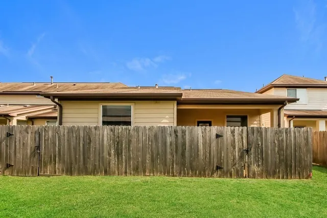 a view of a backyard with wooden fence