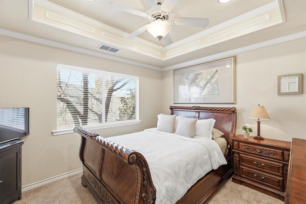 727 Madison Street Coppell, TX 75019 - Photo 26 of 36 a bedroom with a bed and a chandelier