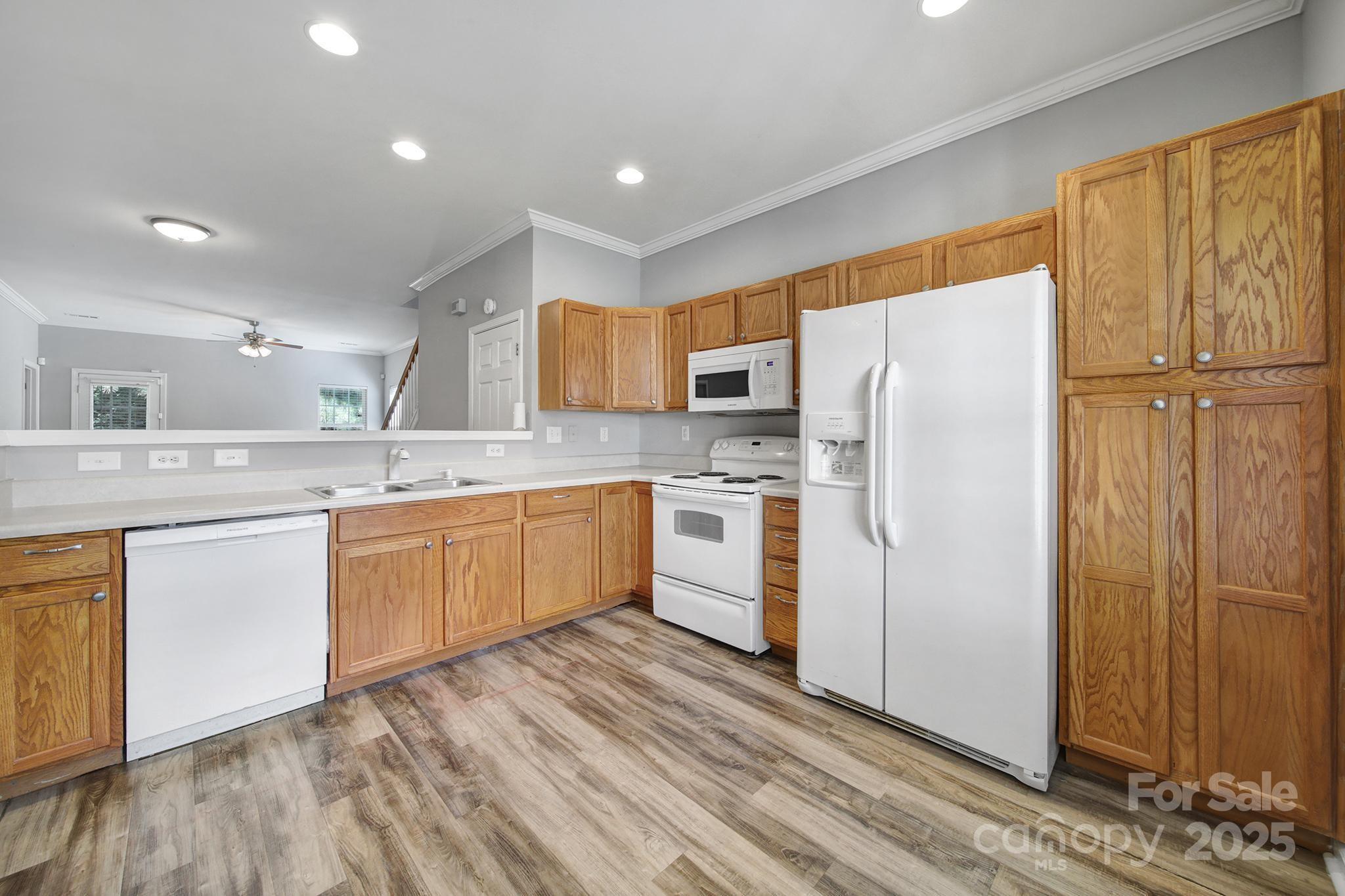 13719 Singleleaf Lane Charlotte, NC 28278 - Photo 6 of 42 a kitchen with a refrigerator a sink and cabinets