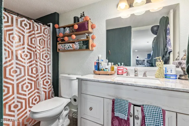 a bathroom with a sink a toilet and a mirror