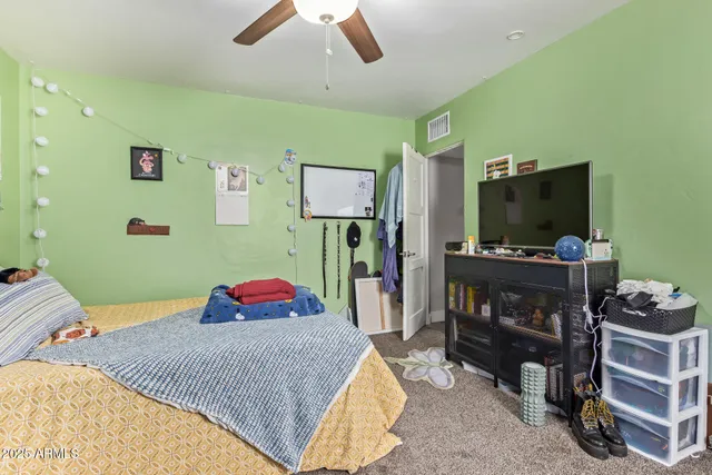 a bedroom with a bed and a flat screen tv