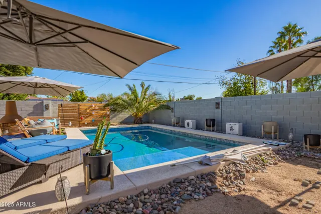 a view of a backyard with plants and table under an umbrella