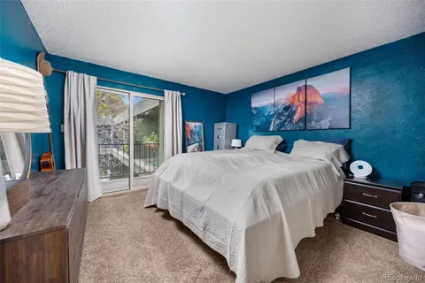 a bed sitting in a spacious bedroom next to a window