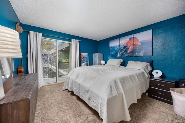 a bed sitting in a spacious bedroom next to a window