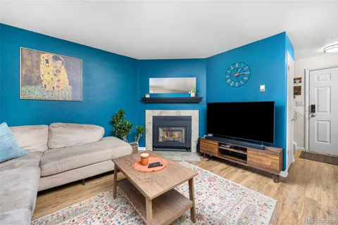 a living room with furniture a flat screen tv and a fireplace