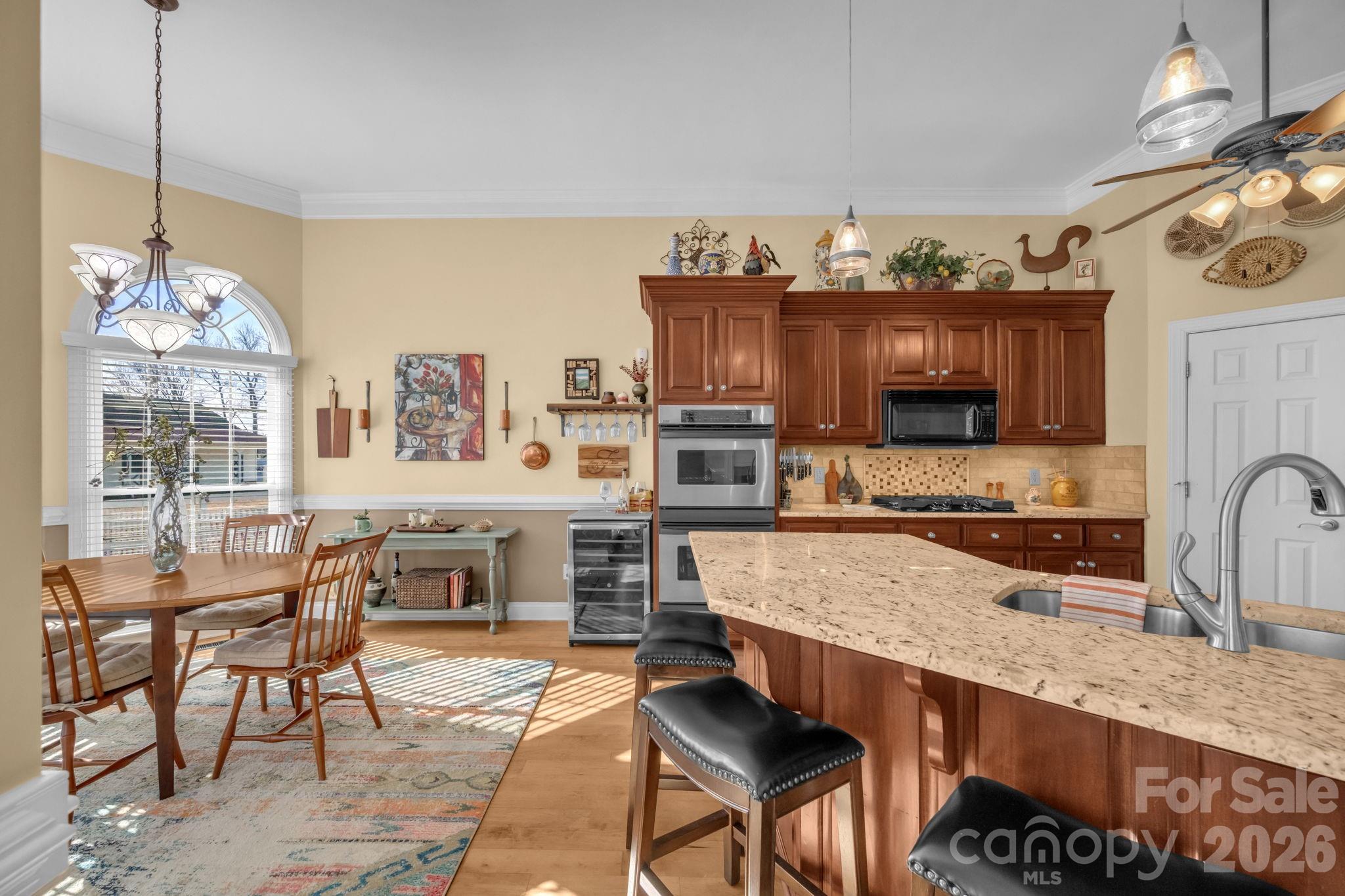 5432 Highway 218 Monroe, NC 28110 - Photo 12 of 48 a kitchen with stainless steel appliances granite countertop a stove top oven a sink a dining table and chairs with wooden floor