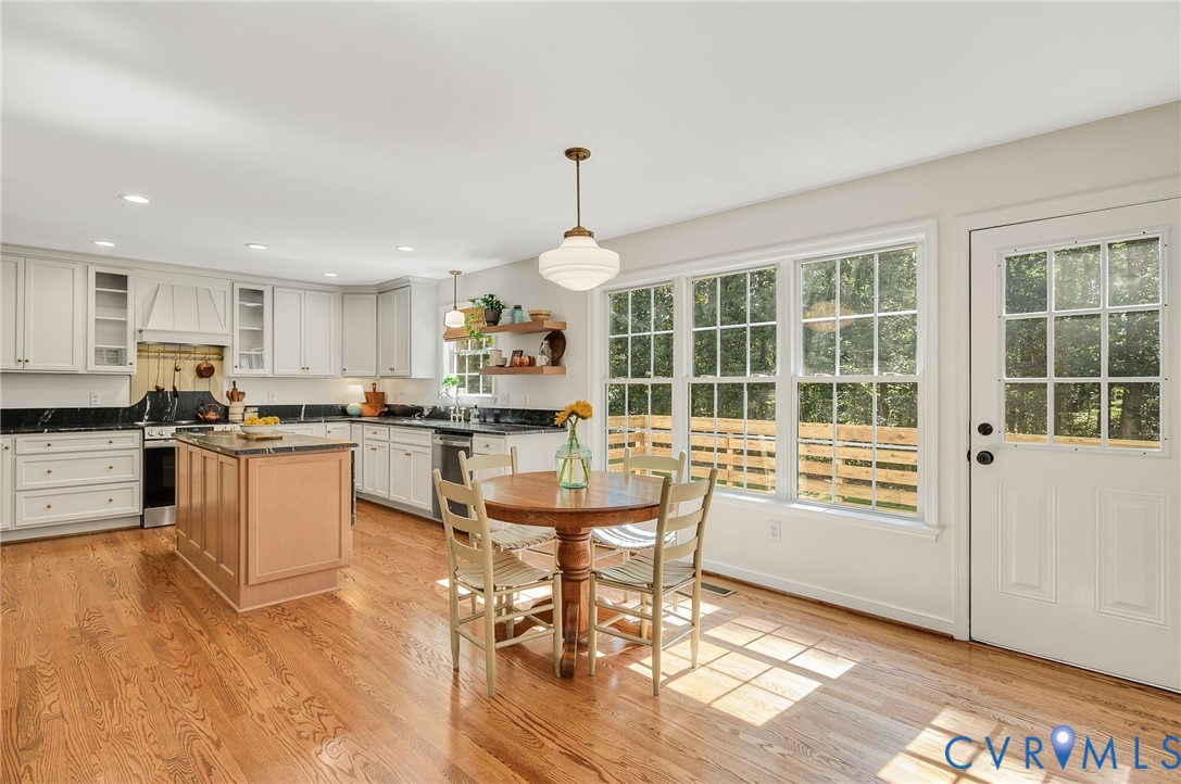 2620 Academy Road Powhatan, VA 23139 - Photo 27 of 49 a kitchen with granite countertop a stove a sink a dining table and chairs with wooden floor