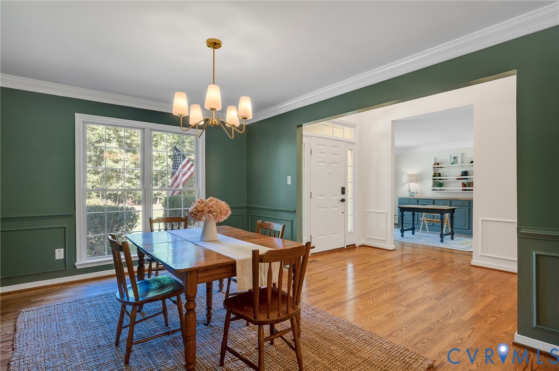 2620 Academy Road Powhatan, VA 23139 - Photo 10 of 49 a dining room with wooden floor a chandelier a wooden table and chairs