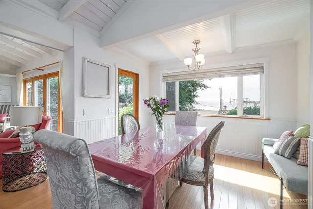 a dining room with furniture a large window and wooden floor