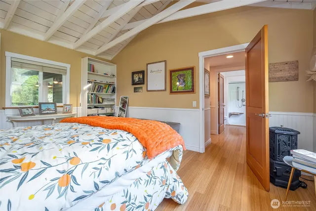 a bed sitting in a spacious bedroom next to a window