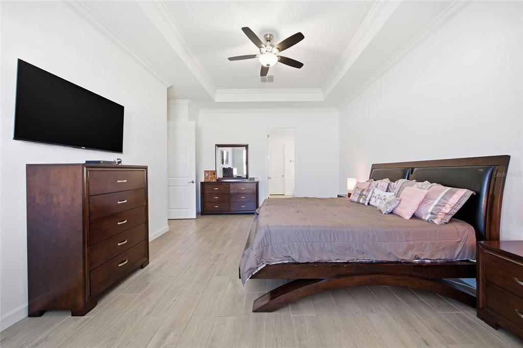 17301 Scuba Crest Street Wimauma, FL 33598 - Photo 11 of 37 a bedroom with a bed and a flat screen tv
