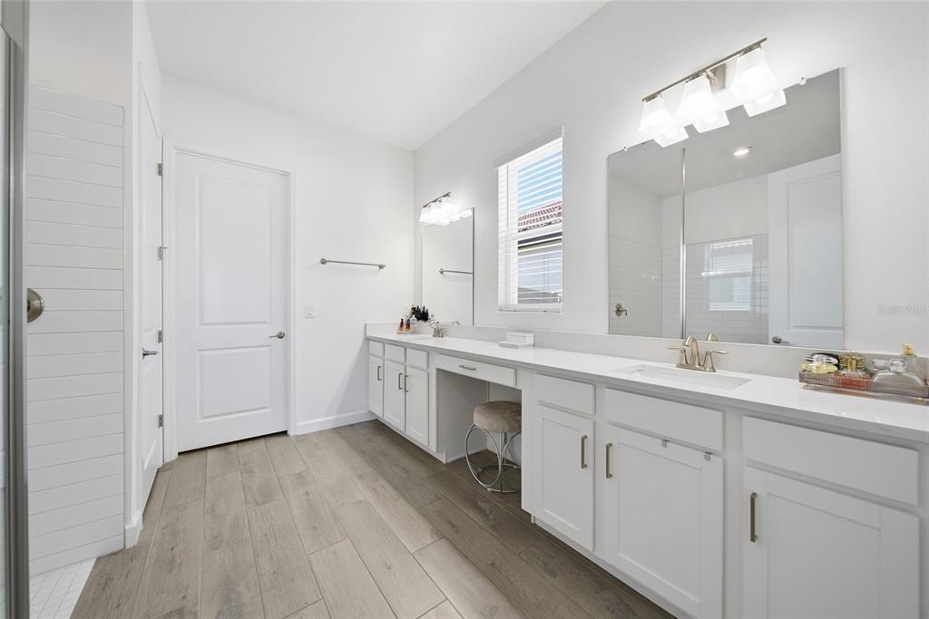 17301 Scuba Crest Street Wimauma, FL 33598 - Photo 12 of 37 a spacious bathroom with a double vanity sink a mirror and a bathtub