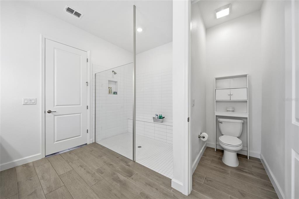 17301 Scuba Crest Street Wimauma, FL 33598 - Photo 13 of 37 a bathroom view of a toilet and a wooden floor
