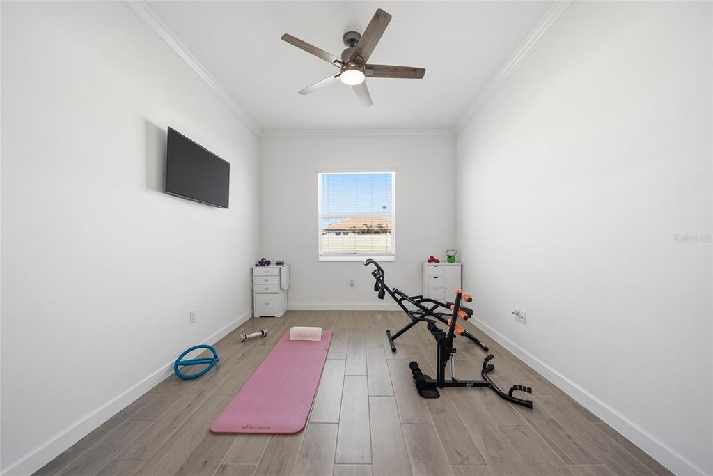 17301 Scuba Crest Street Wimauma, FL 33598 - Photo 17 of 37 a room with gym equipment and a wooden floor