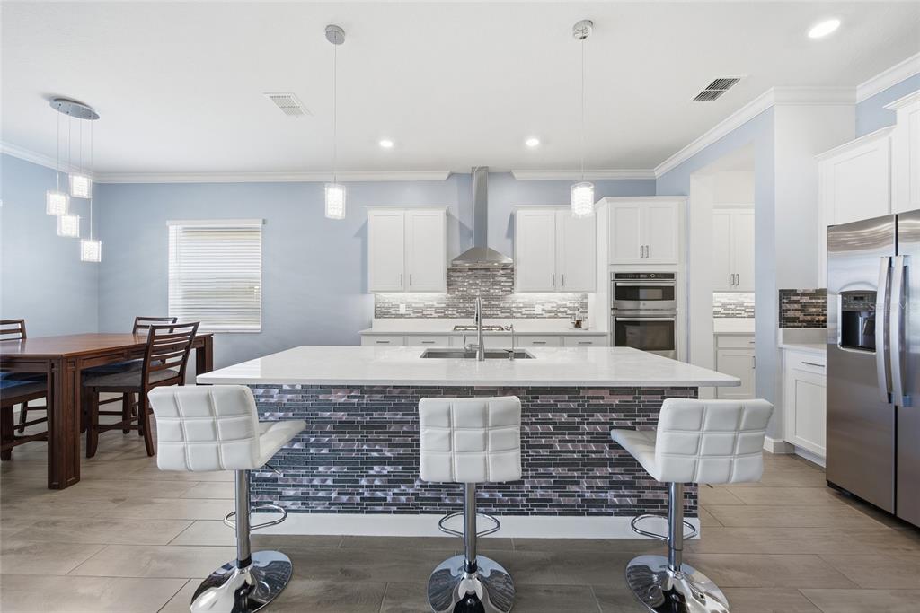 17301 Scuba Crest Street Wimauma, FL 33598 - Photo 4 of 37 a large kitchen with a table and chairs